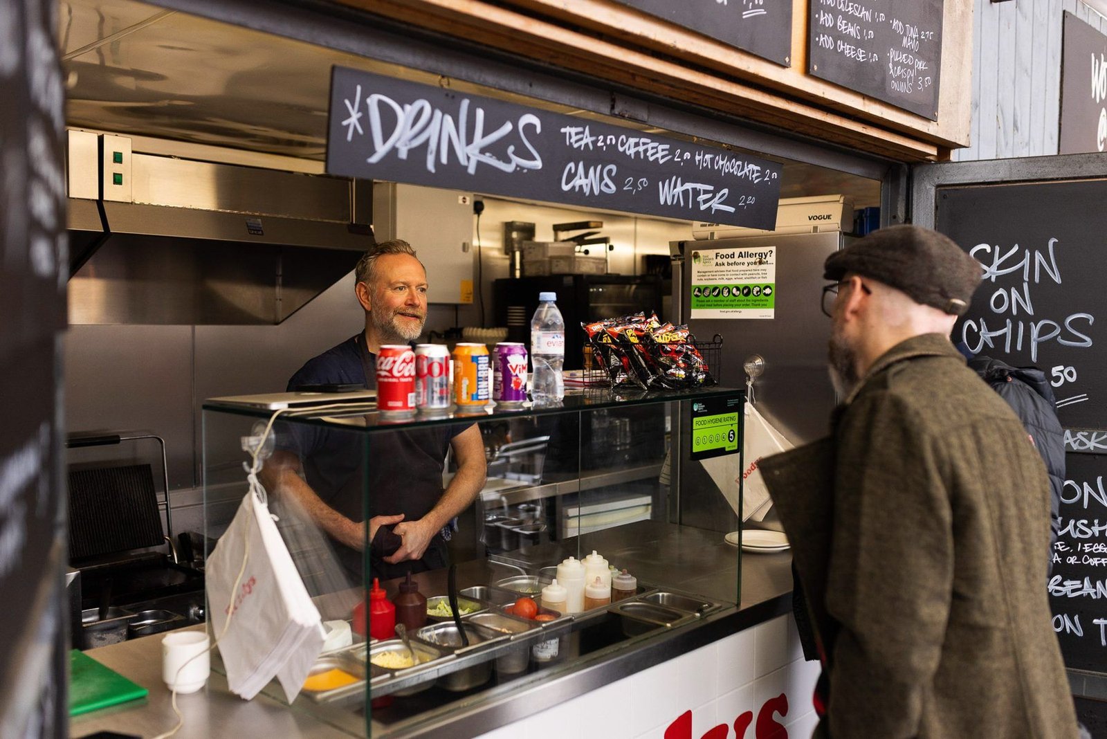 James talking with a business owner at a market stall