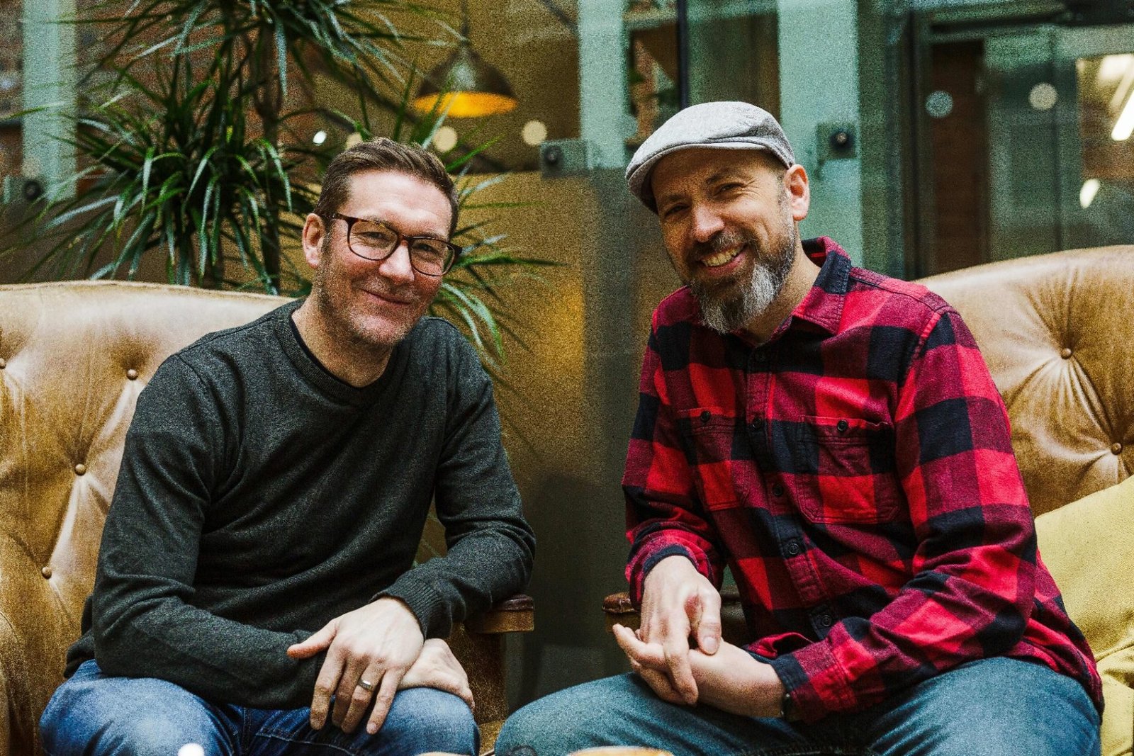James and Garry smiling on a sofa